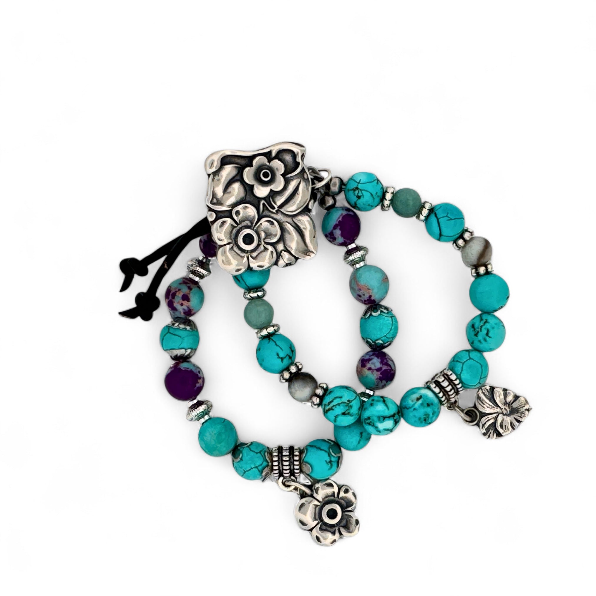 Turquoise beaded bracelet with silver floral charms on a white background